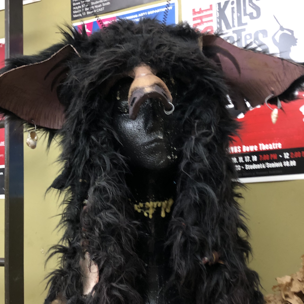 A monster headpiece on a stand, covering the head and forhead but not the face. It has wide pointy ears and messy black fur. Link takes you to project page.