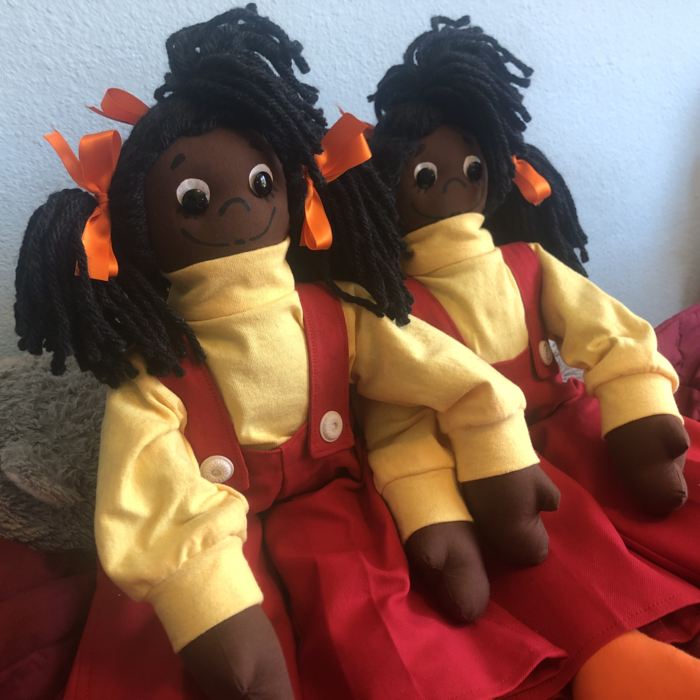 A Black rag doll wearing a yellow turtleneck and orange overalls. Link takes you to project page.