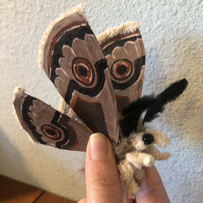 A handmade moth with painted fabric wings, fluffy body, and large black beady eyes. Link takes you to project page.