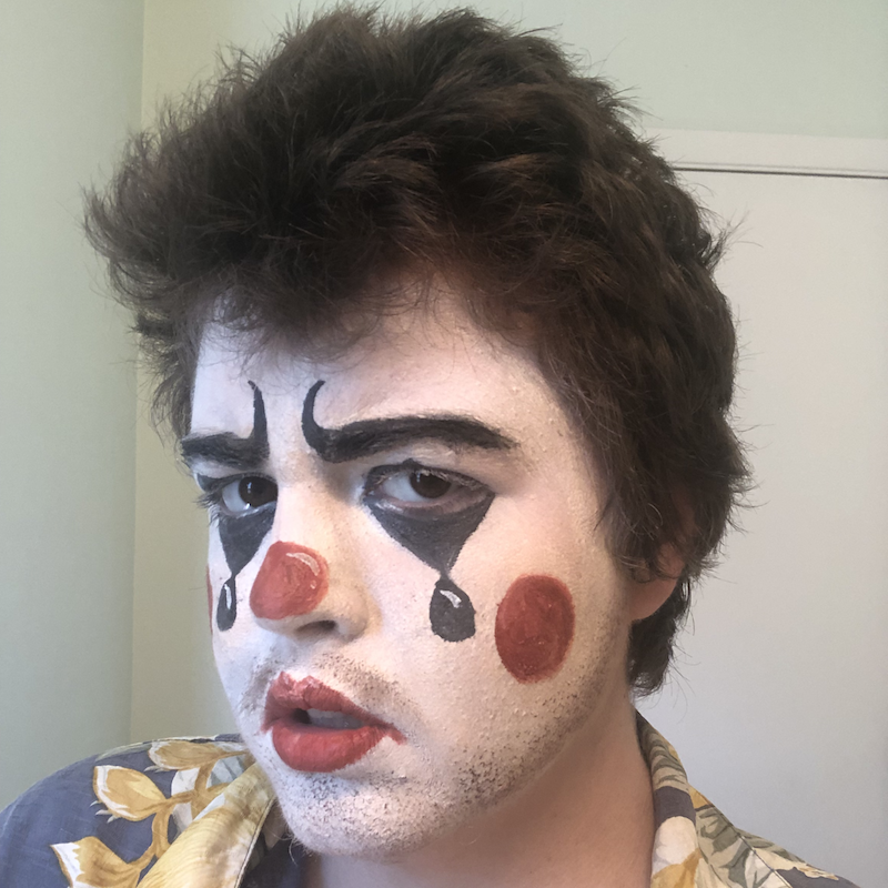 A headshot of a person in clown makeup, they have tears drawn under their eyes and stubble. Link takes you to project page.