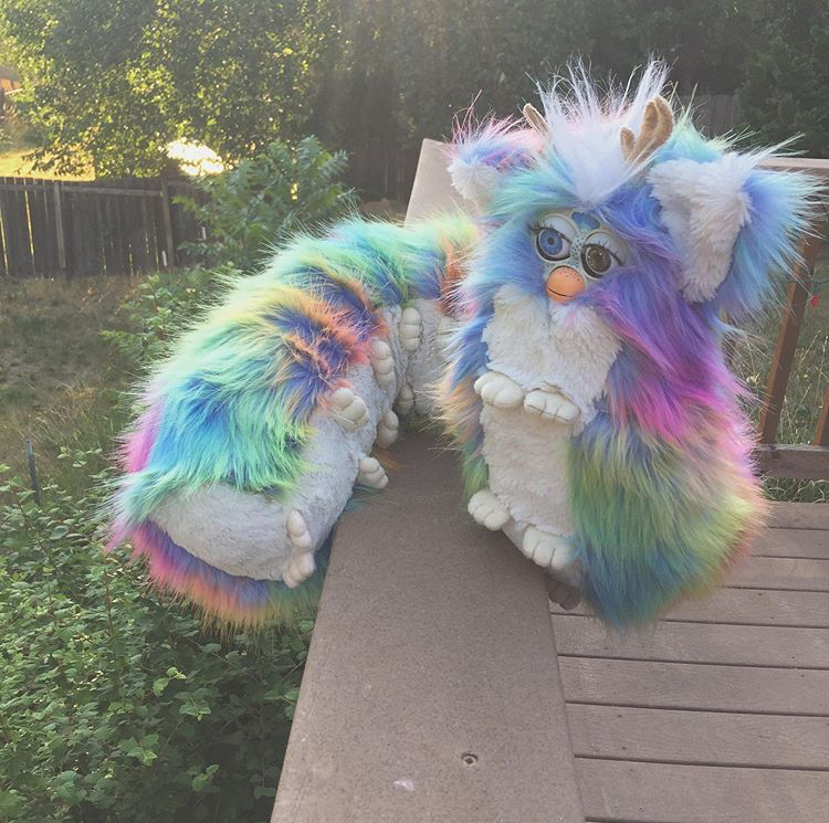 A long worm-like plush creature with rainbow fur, a white belly, and multiple pairs of feet. Picture links to project page.