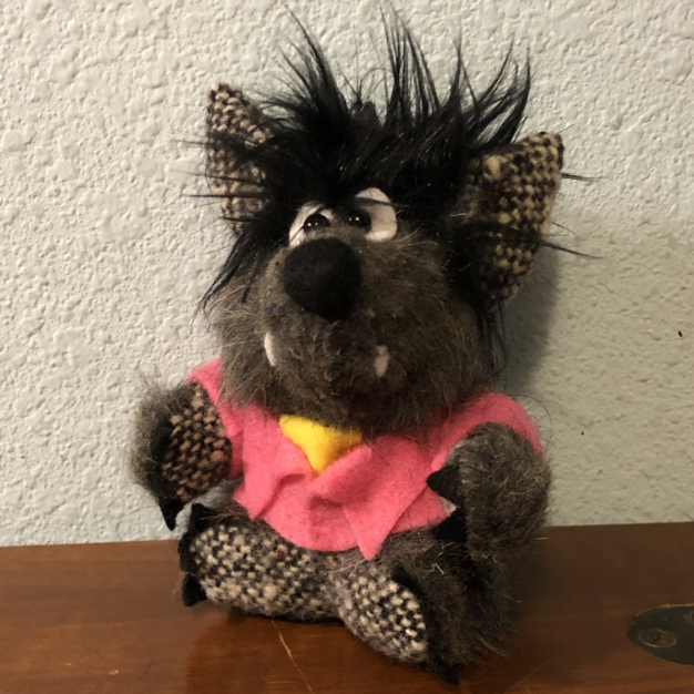 A small plush of a grey wolf, wearing a pink jacket and green beret. Picture links to project page.Picture links to project page.